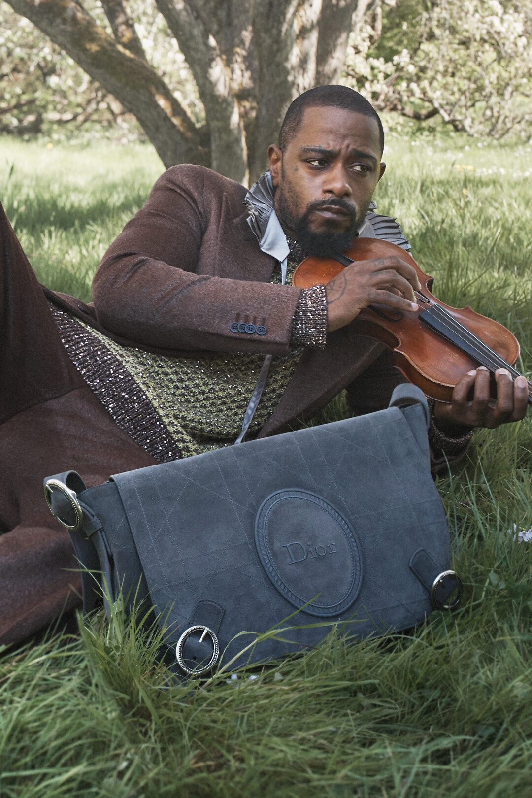 Homem com violino deitado na grama, campanha masculina